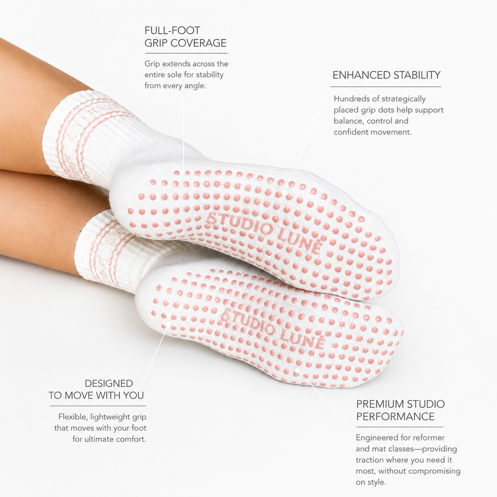 White socks with pink textured grip sole on a white background, featuring text about grip and stability.