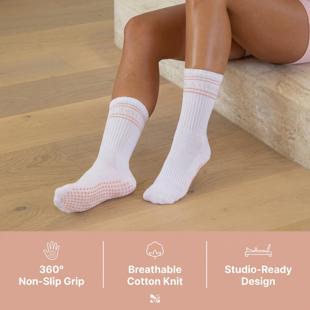 Person wearing light pink socks with textured sole on a wooden floor, featuring product benefits text.
